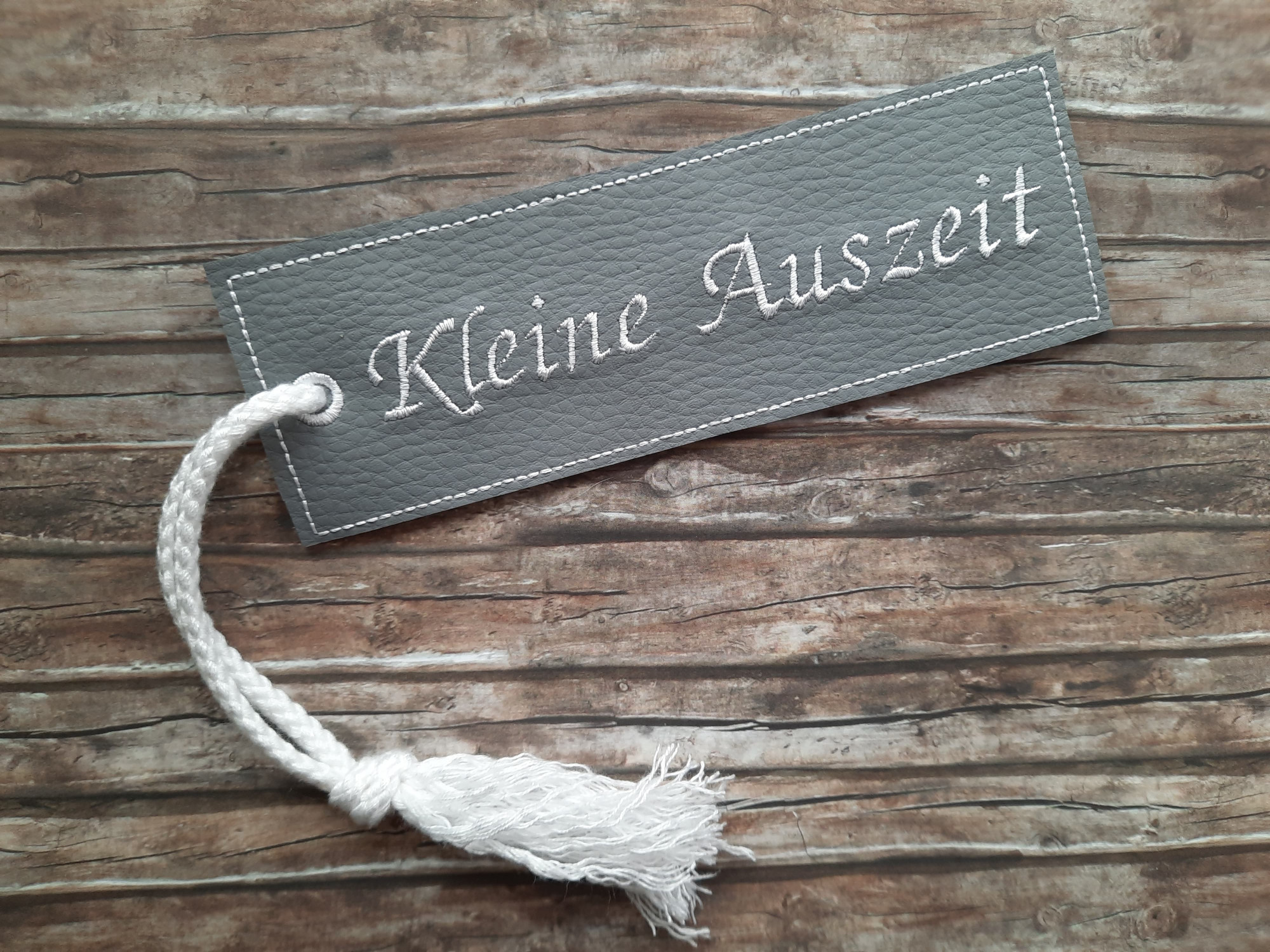 Lesezeichen aus Kunstleder mit Schriftzug "Kleine Auszeit"